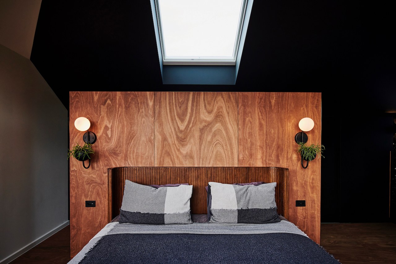 Lanes End bedroom with fluted timber bedhead and skylight