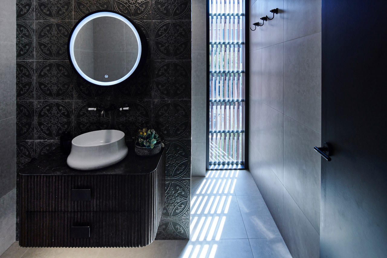 Lanes End bathroom with round mirror and black tile